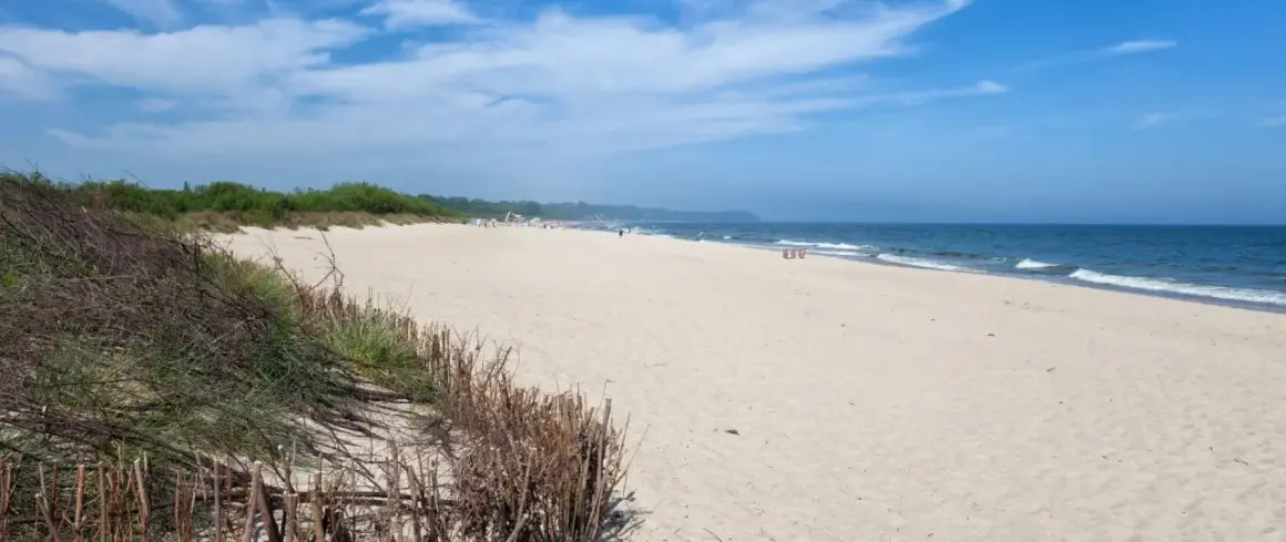Plaża we Władysławowie, idealne miejsce na wypoczynek. Piasek, morze i zielone wydmy tworzą piękne krajobrazy, a liczne atrakcje czekają na turystów.