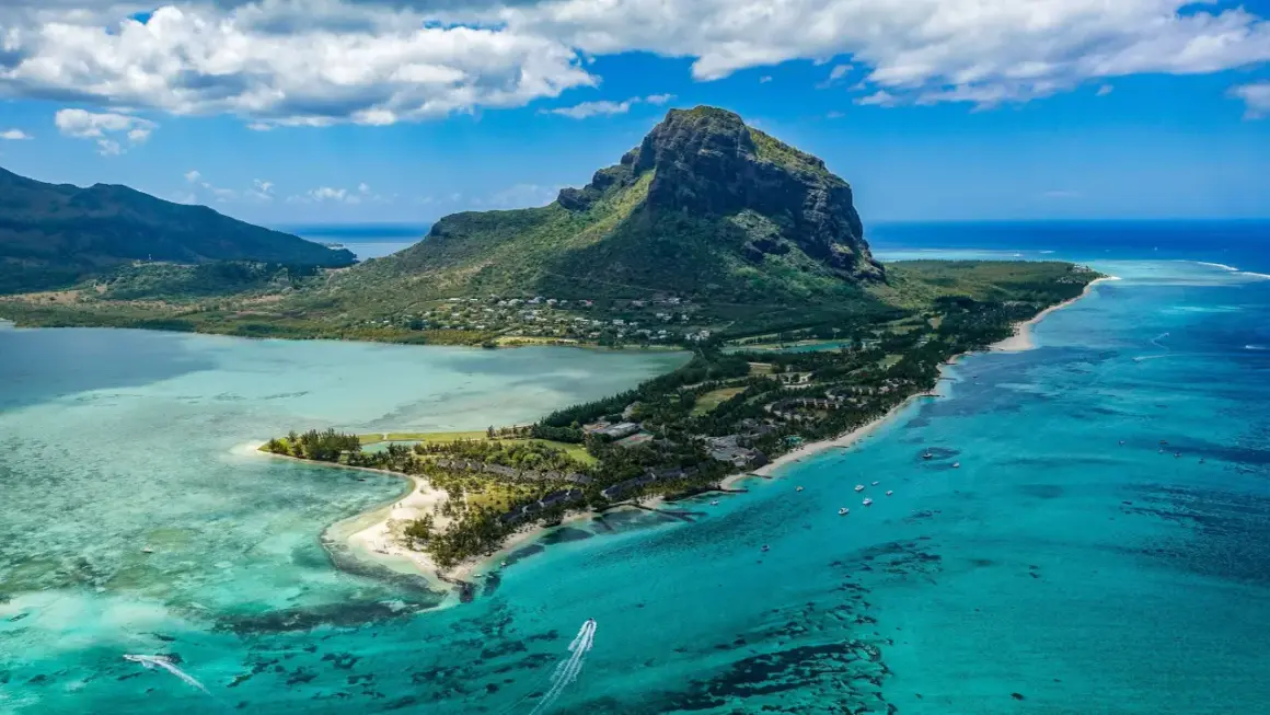 Rajska plaża na Mauritiusie, gdzie turkusowa woda i bujna zieleń zachęcają do relaksu. Pamiętaj o Mauritius szczepienia przed podróżą!