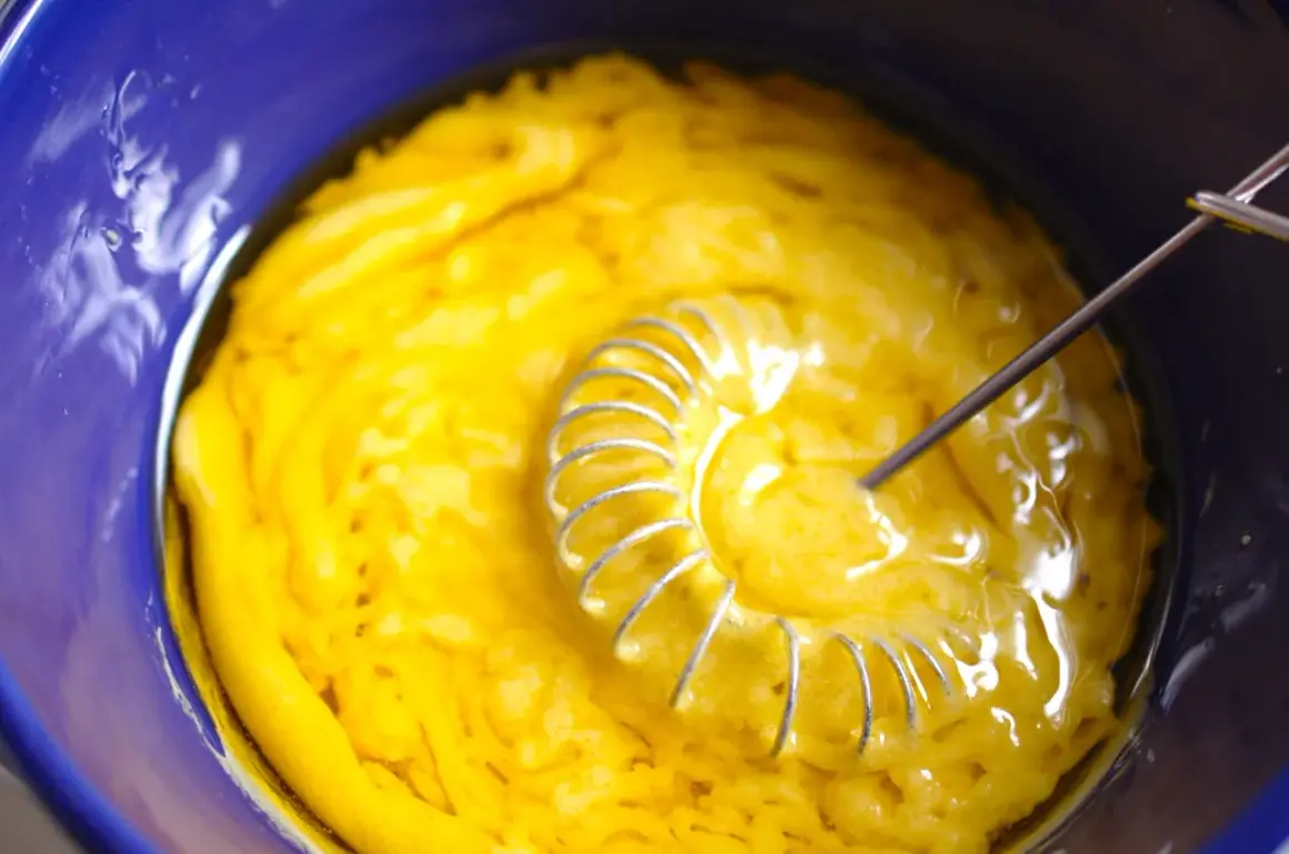 Gelbe Masse wird in blauer Schüssel mit Schneebesen verrührt. Das ist die Basis für eine leckere Vinaigrette.