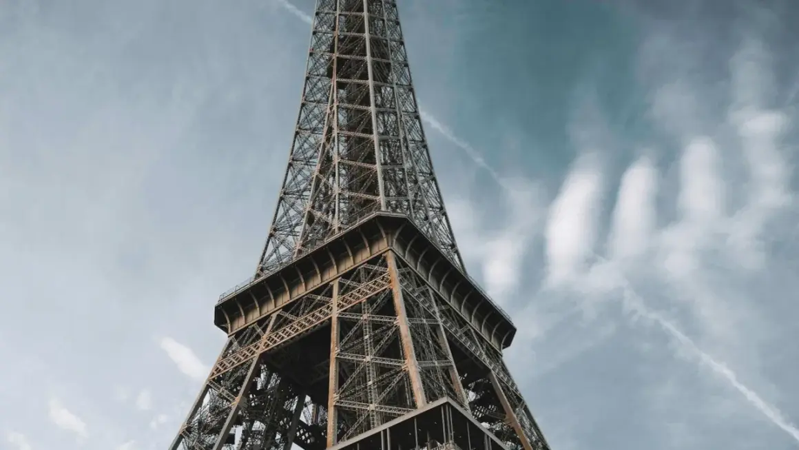 La **Eyfel Kulesi** se dresse fièrement sous un ciel bleu parsemé de nuages.
