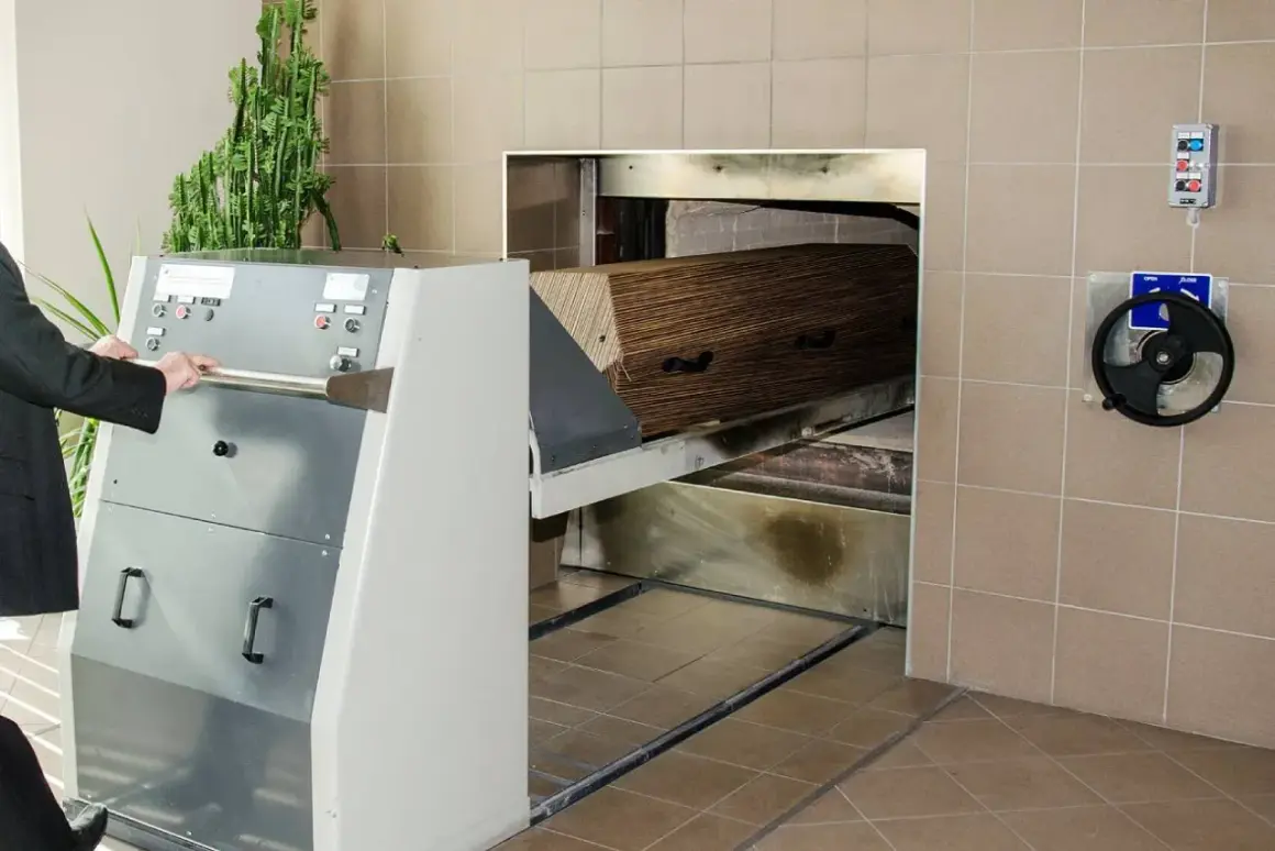 Wózek z trumną wjeżdża do pieca kremacyjnego. Proces ten nie powoduje bólu, jest to ostatnie pożegnanie.