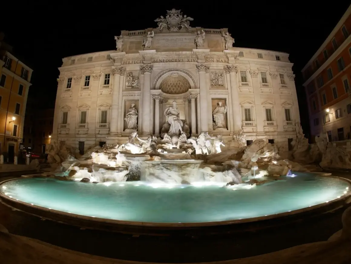 Fontanna di Trevi nocą, majestatyczna fontanna we Włoszech, z turkusową wodą i rzeźbami.