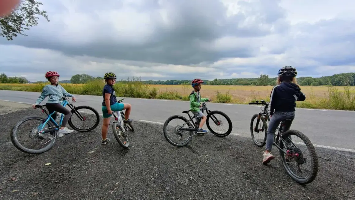 Cztery dzieci na rowerach, zastanawiają się, jaki rower dla 8 latka 20 czy 24 cali będzie najlepszy.