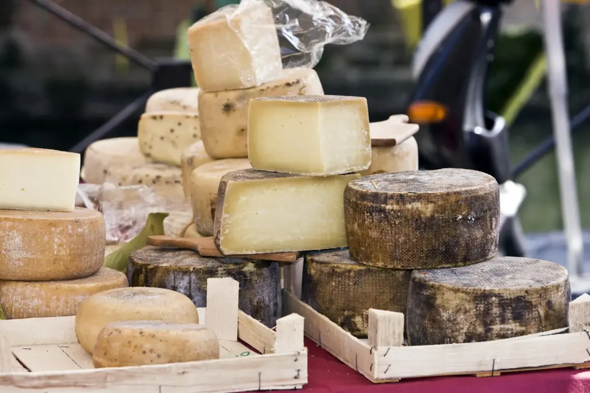 Un étalage de fromages variés, dont un beau fromage parisien, empilés et prêts à être dégustés.