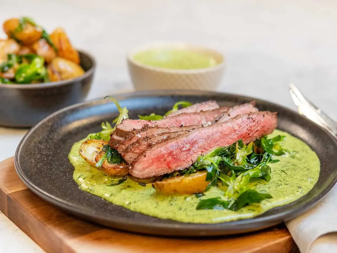 Skivad flankstek med perfekt flankstek temp, serverad med rostade potatisar och en krämig örtsås.