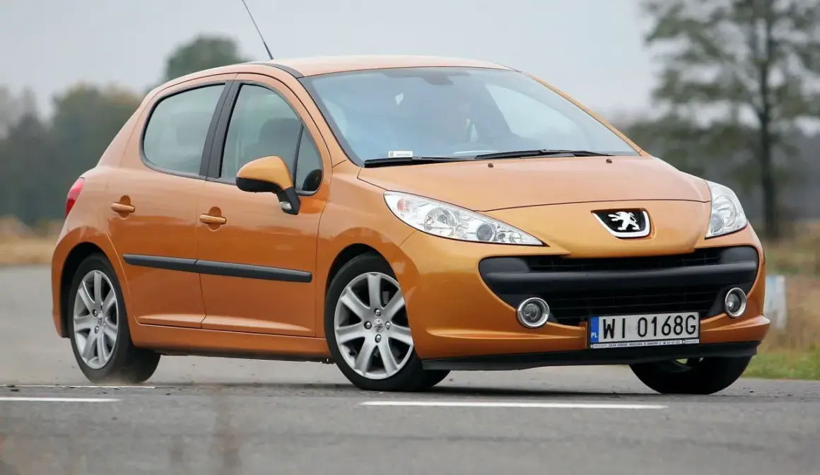 Pomarańczowy Peugeot 207 1.6 HDi na drodze.