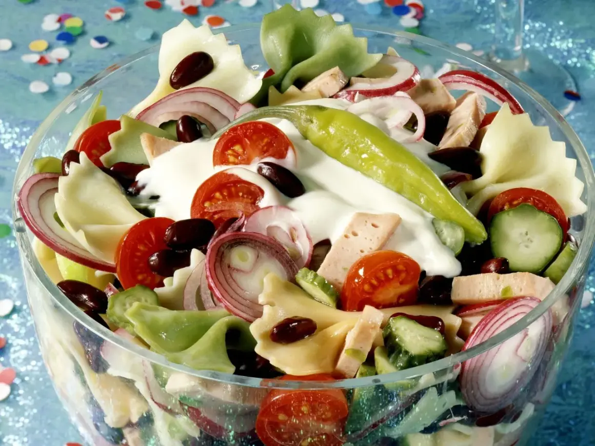 Bunter Nudelsalat mit Tomaten, Gurken, Zwiebeln, Bohnen und einem grünen Chili. Leckere schnelle Salate ohne Mayo sind perfekt für jede Gelegenheit.