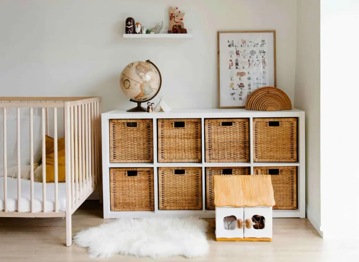 Schöne kinderzimmer ordnung ideen: ein Gitterbett, ein Regal mit Weidenkörben, Spielzeug und ein Globus.