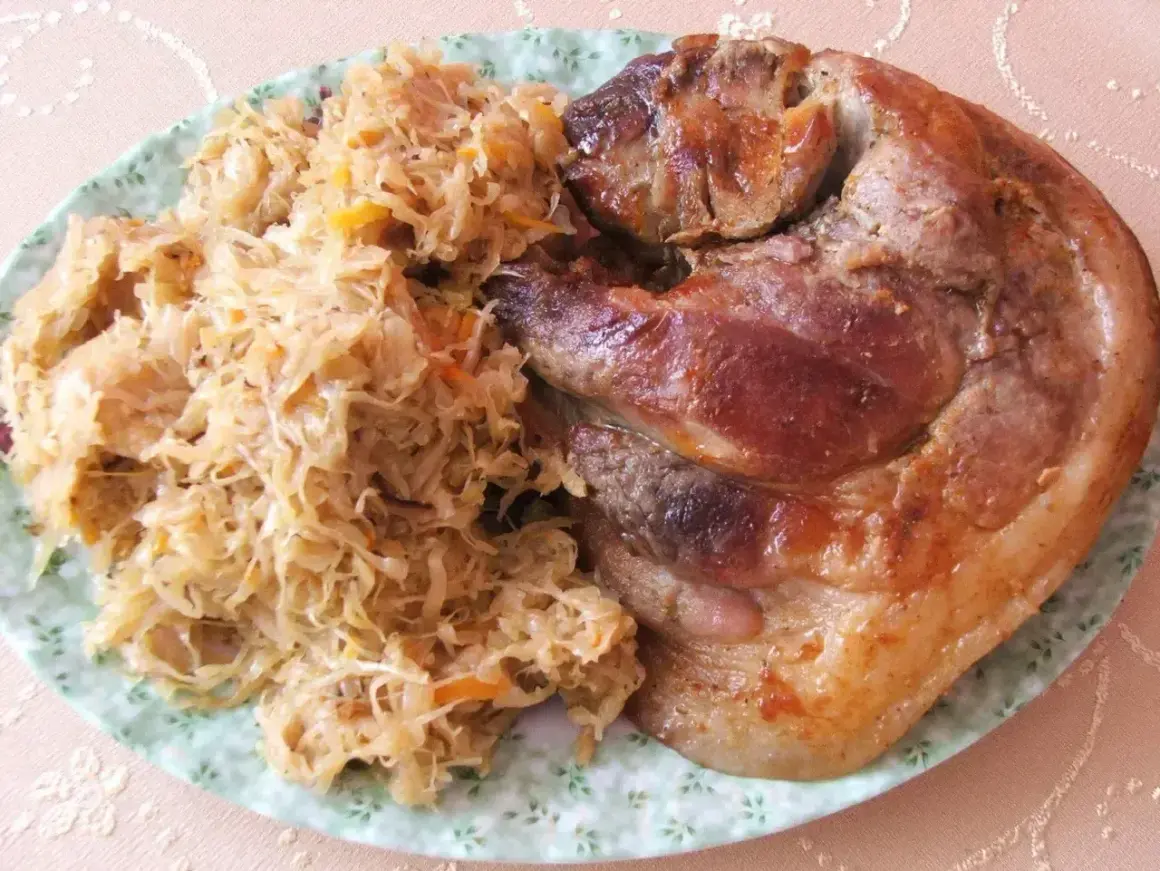 Pyszna golonka w kapuście kiszonej, pieczona do perfekcji, z chrupiącą skórką i soczystym mięsem. Idealny polski obiad.