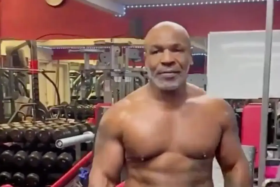 Mike Tyson's impressive muscles are on full display in a gym setting, surrounded by weights and equipment.