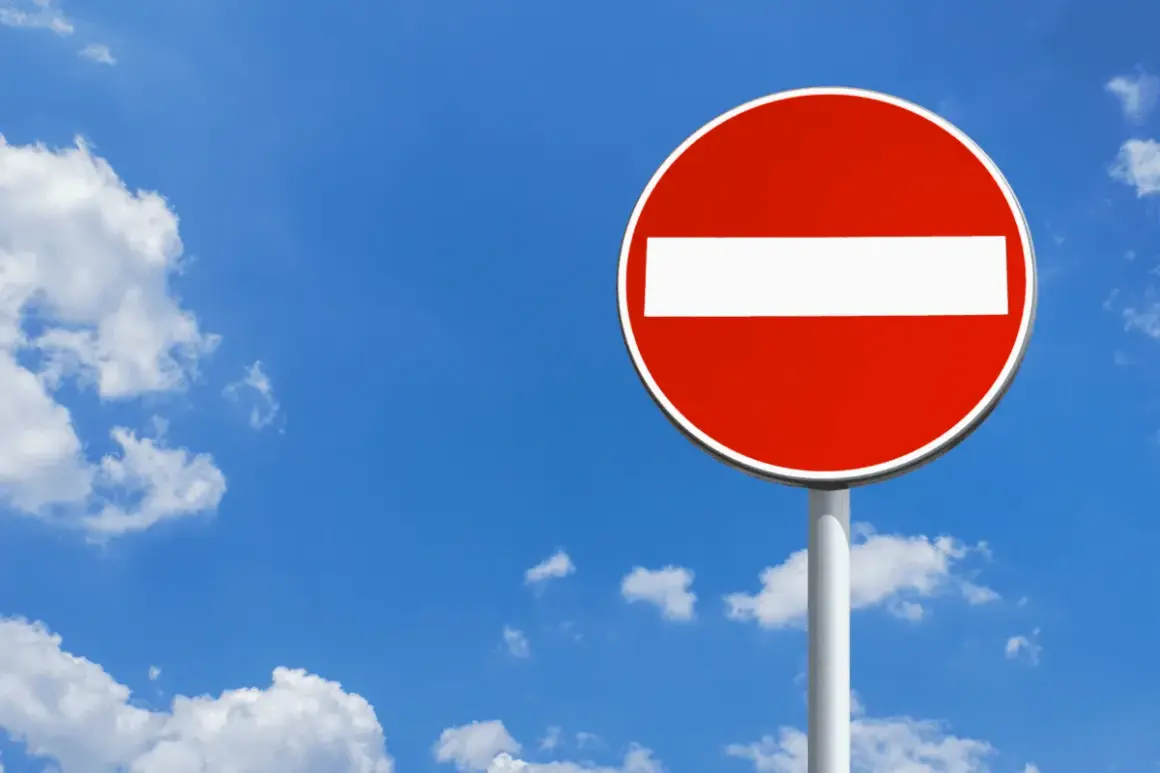 Panneau sens interdit rouge et blanc sous un ciel bleu avec des nuages. Combien de points pour un sens interdit ? Zéro, c'est une interdiction !