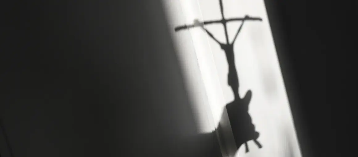 Schatten eines Kreuzes mit Jesusfigur, der eine kritische Auseinandersetzung mit evangelischen Freikirchen andeutet.