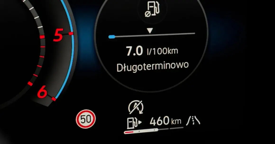 Na desce rozdzielczej widać wskaźnik paliwa, prędkościomierz i ikonę drogi. Długoterminowe spalanie to 7.0 l/100km. Zasięg 460 km. Czas start stop.