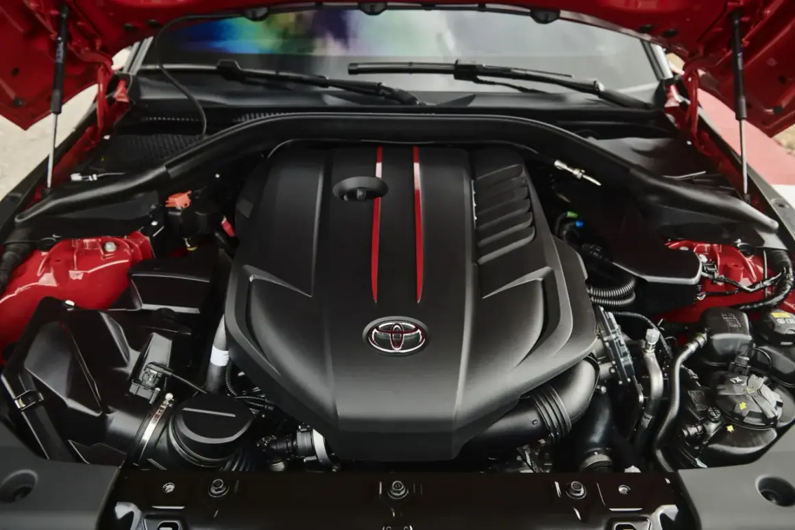 El potente motor del Supra, con su distintivo logo de Toyota y detalles rojos, listo para la acción.