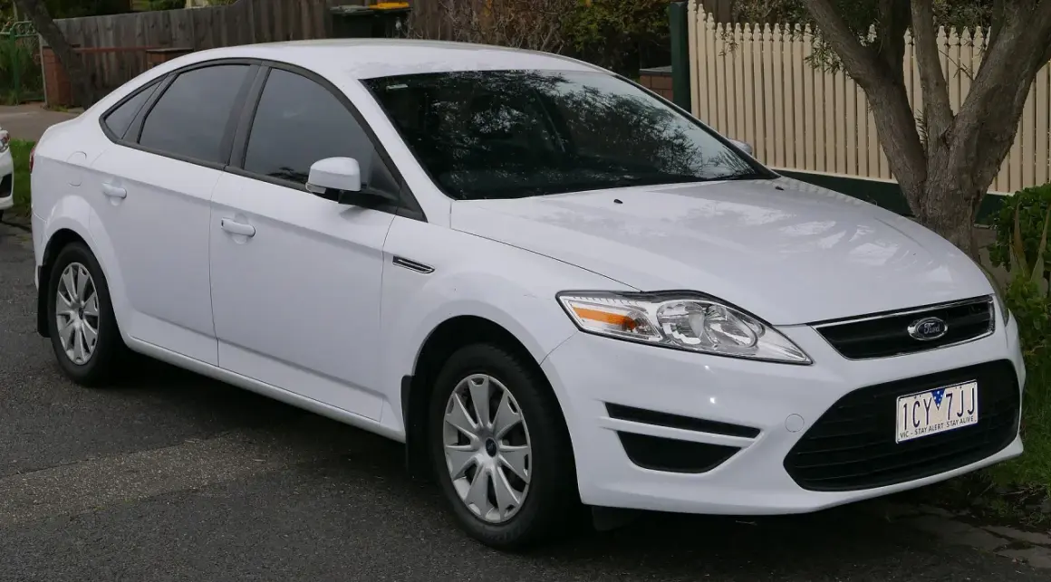 Biały Ford Mondeo MK4, często chwalony w opiniach za komfort i przestronność, zaparkowany na ulicy.