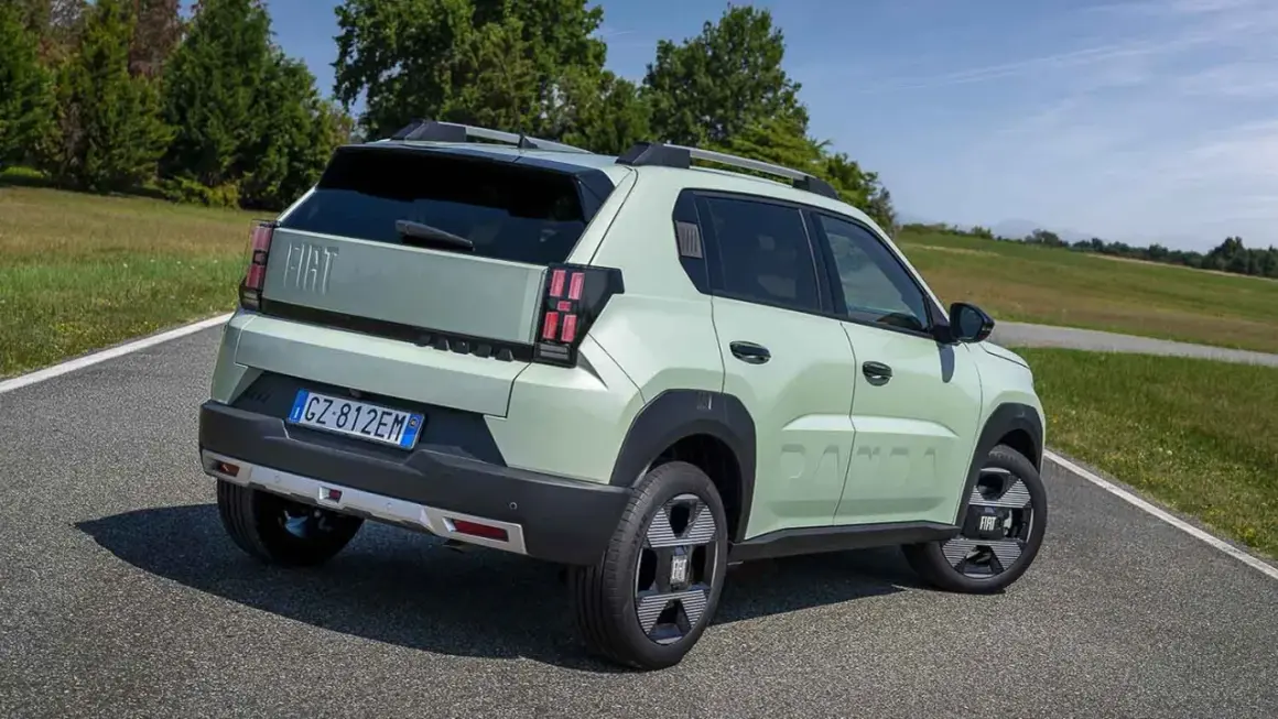 Jasnozielony Fiat Panda, jeden z najlepszych hatchbacków, na tle zielonych wzgórz.