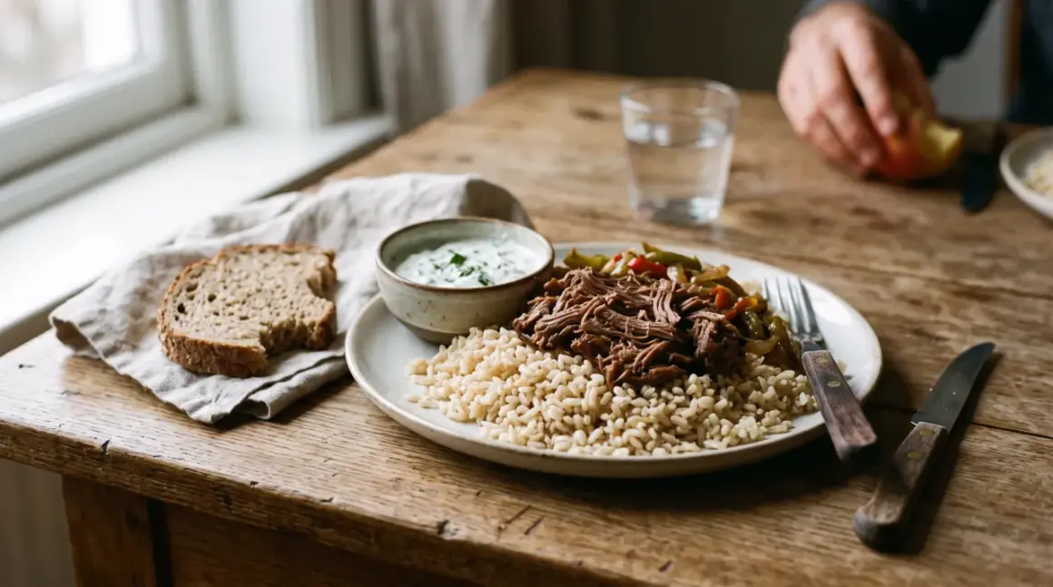 Un repas prise de masse copieux : riz brun, effiloché de bœuf, légumes sautés et une sauce crémeuse. Une tranche de pain complète accompagne ce plat.