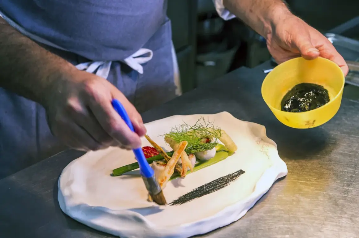 Szef kuchni w restauracji z gwiazdką Michelin precyzyjnie dekoruje danie.