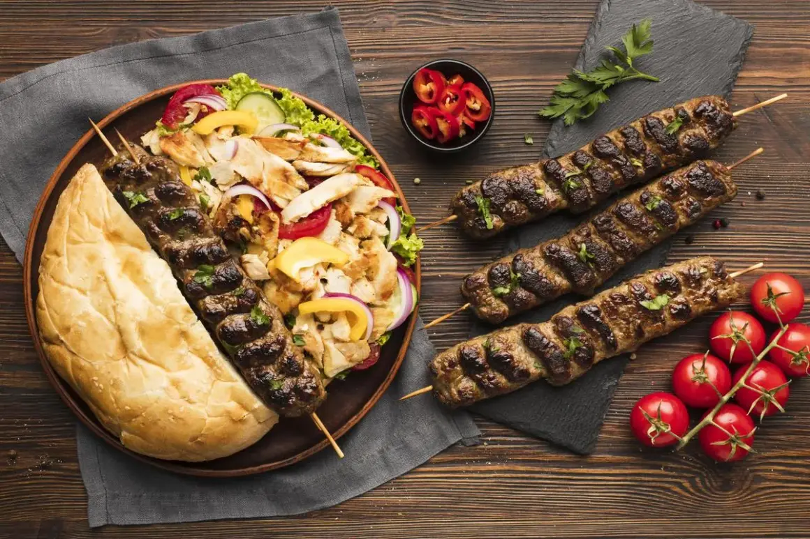 Un plateau de kebab et frites, avec des brochettes de viande grillée, du pain pita, une salade fraîche et des tomates. Un repas gourmand, attention à la calorie kebab frite !