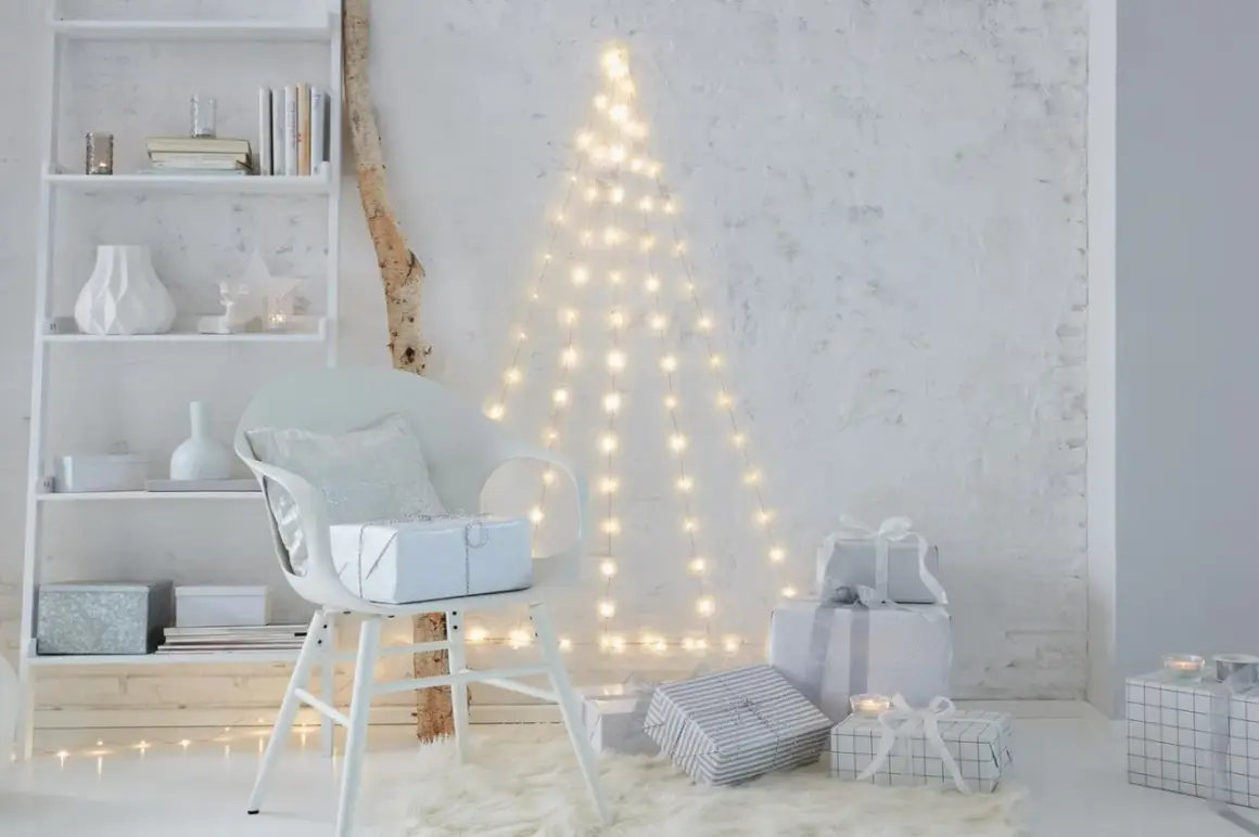 Eine Lichterkette an der Decke befestigt, bildet einen Weihnachtsbaum. Geschenke und ein Stuhl stehen davor.