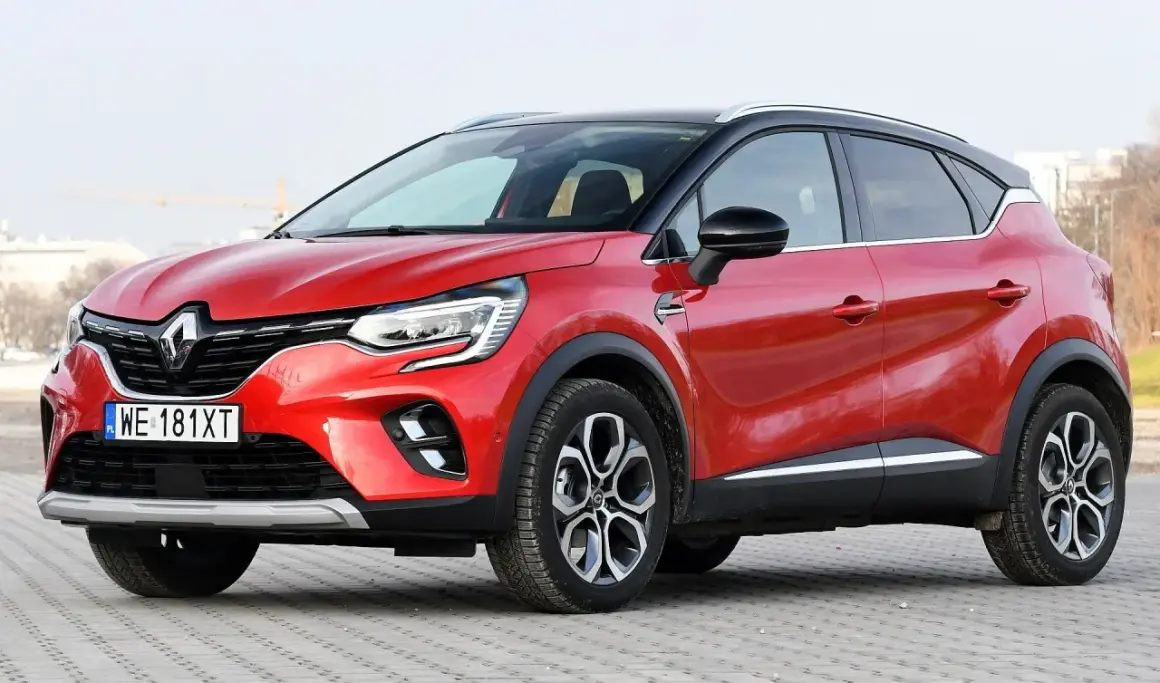 Czerwony Renault Captur na tle miejskiego krajobrazu. Zastanawiasz się, renault captur jaki silnik wybrać?