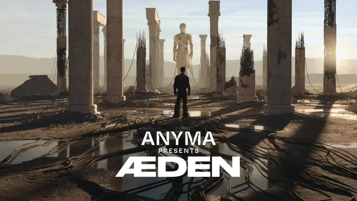 Mężczyzna stoi przed ruinami starożytnych kolumn, patrząc na gigantyczny posąg. Anyma Presents ÆDEN – zapowiedź koncertu.