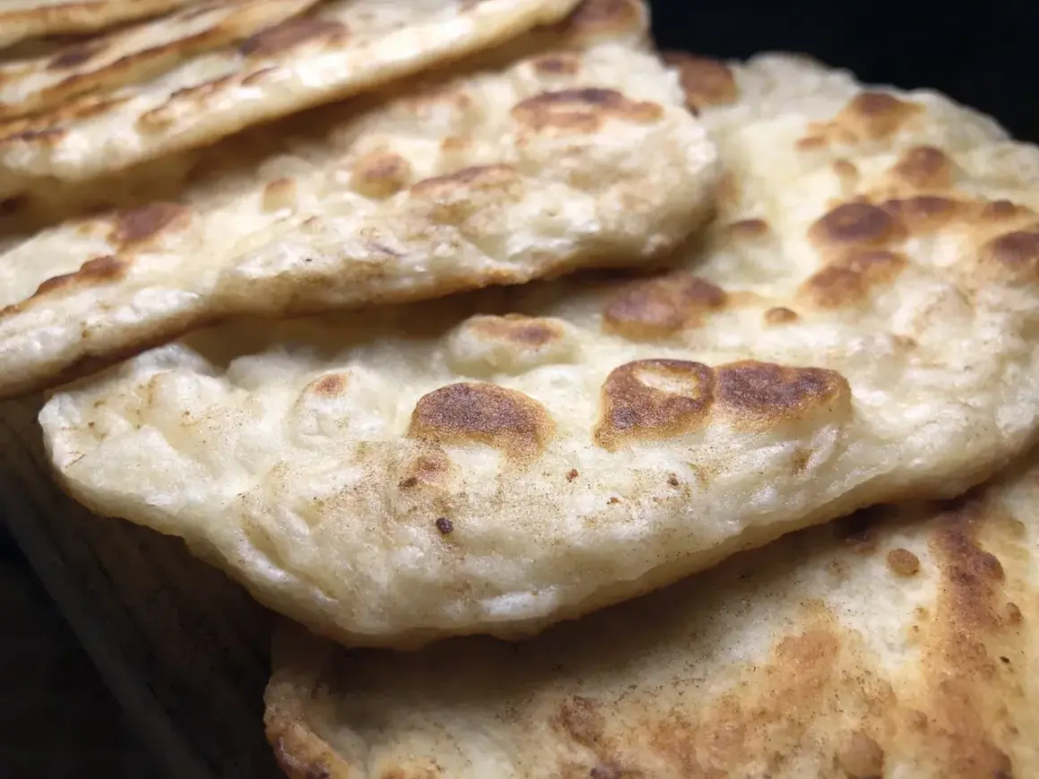 Stos chlebków naan, idealnych do indyjskich dań. Gdzie kupić świeży chlebek naan?