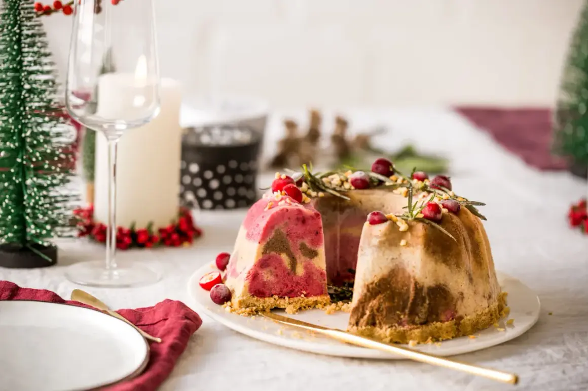 Festliches Eis-Weihnachten: Marmorierte Eistorten mit Cranberries und Rosmarin, dekoriert für ein festliches Mahl.