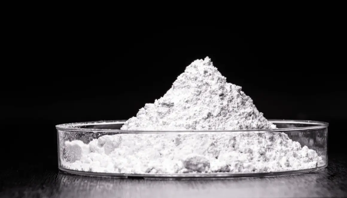 Feiner weißer Pulverberg in einer Petrischale. Dieses Titandioxid ist ein wichtiger Inhaltsstoff in Kosmetikprodukten, z.B. für Sonnenschutz.