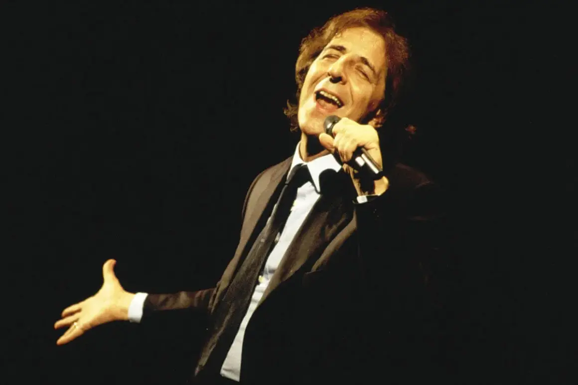 Giorgio Gaber canta con passione, la sua voce risuona come nei testi de "Il Conformista", un'icona della musica italiana.