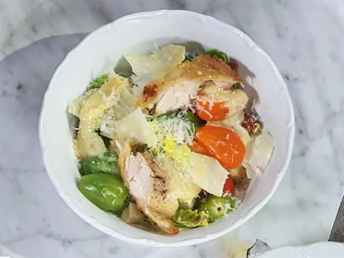En härlig caesarsallad med kyckling, parmesan och krutonger, generöst täckt med krämig caesarsallad dressing.