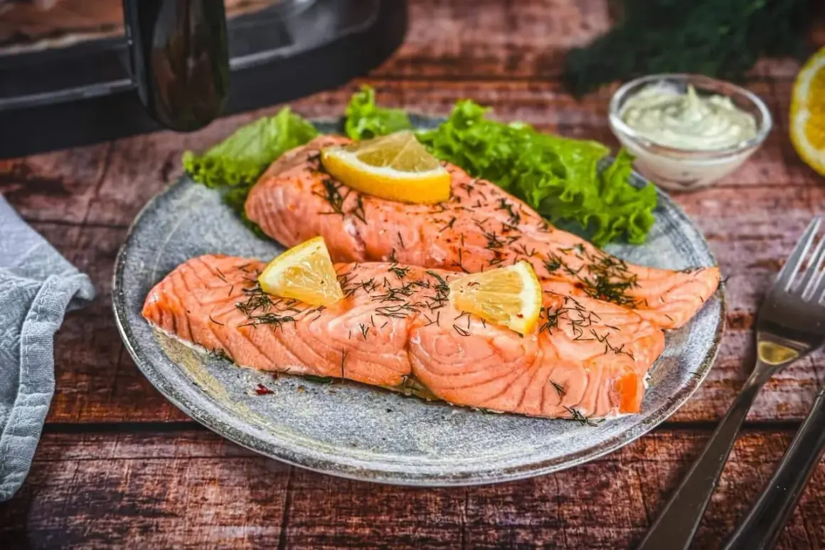 Zwei saftige Lachsfilets, perfekt im Airfryer zubereitet, garniert mit Zitrone und Dill. Dazu knackiger Salat und eine cremige Sauce.