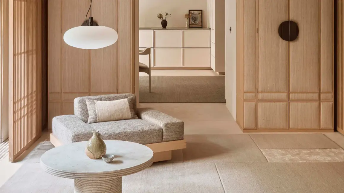 Gemütliches Wohnzimmer im Japandi Stil mit Sofa, Couchtisch und Holzelementen.