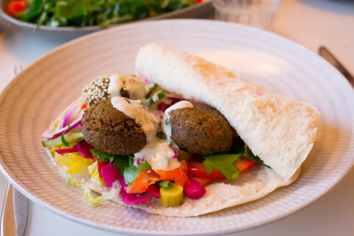 Falafel i pitabröd med färgglada grönsaker och en krämig sås. Ett perfekt falafel recept för en snabb och god lunch.