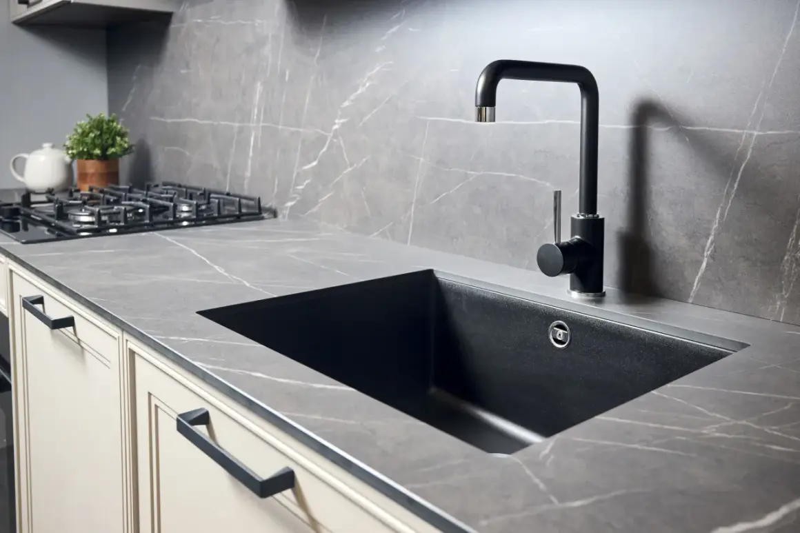 Piano cucina in quarzo effetto marmo con lavello nero e rubinetto moderno. Perfetto per forare top cucina per lavello.