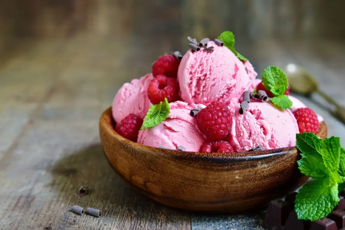 Himbeereis selber machen ohne Eismaschine: Cremiges Eis mit frischen Himbeeren und Minze in Holzschale.