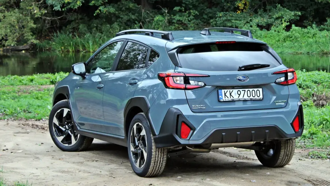 Szary Subaru Crosstrek 2025 na tle zieleni i wody. Gotowy na przygodę!