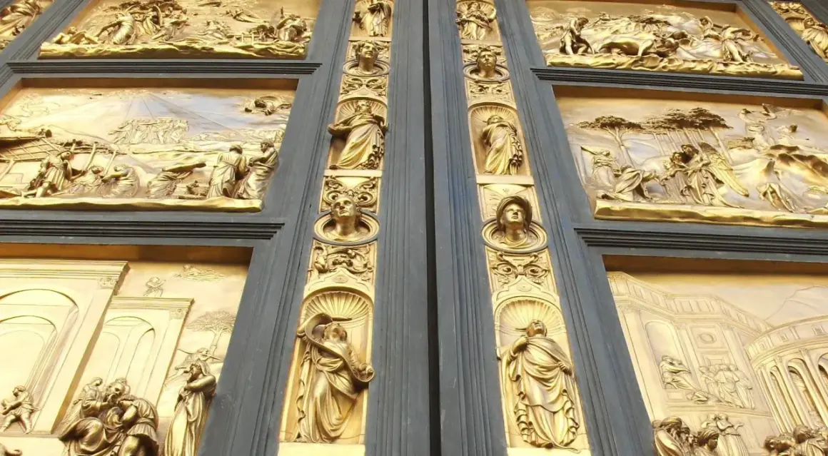 Detalle de las puertas del paraíso, con relieves dorados que narran escenas bíblicas y figuras alegóricas.