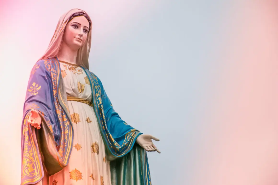 Statue der Maria, die ihre Hand ausstreckt, als würde sie zu einer Marienandacht im Mai einladen.
