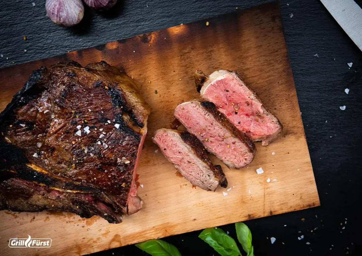Perfekt gegrilltes T-Bone-Steak, aufgeschnitten, um die ideale Kerntemperatur und saftige Textur zu zeigen.