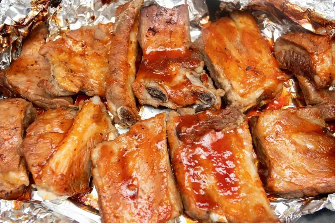 Soczyste żeberka w sosie BBQ, pieczone w folii aluminiowej, kuszą apetycznym wyglądem.