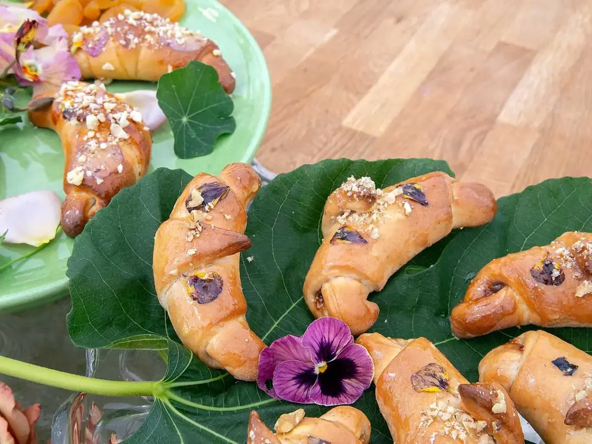 Gyllene gifflar med nötter och torkad frukt, vackert arrangerade på gröna blad. Ett härligt recept på hembakade gifflar!