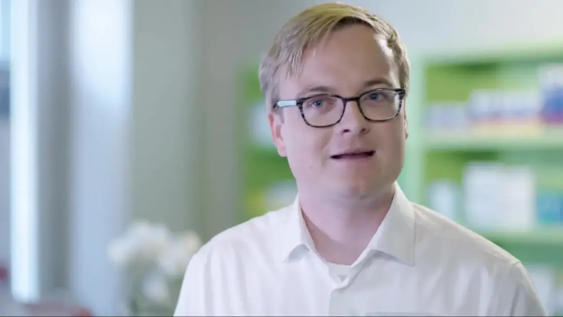 Ein Mann mit Brille in einem weißen Hemd spricht. Er erklärt, dass es erleada eine Chemotherapie ist.