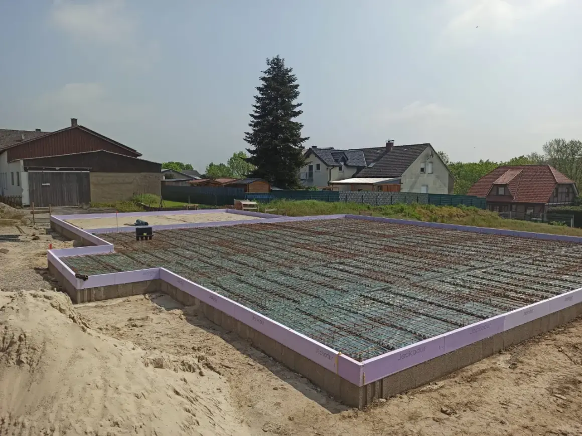 Fundament pod dom w Niemczech, gotowy do zalania betonem. Praca na budowlance trwa.