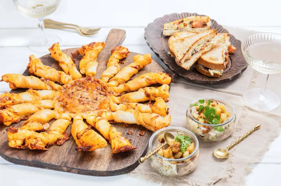 Un apéro réussi : tarte feuilletée en forme de soleil, mini sandwichs, verrines et coupes de champagne. Idéal pour savoir quoi apporter pour une invitation à un apéro.