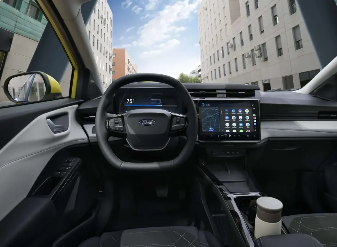 Vue du **ford puma interieur** moderne avec écran tactile, volant multifonction et tableau de bord numérique. La ville s'affiche à travers le pare-brise.