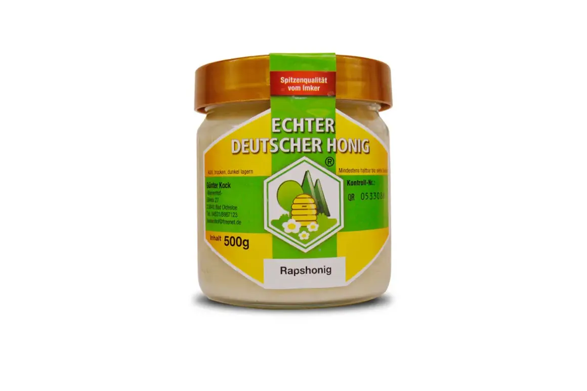 Glas mit cremigem Rapshonig, "Echter Deutscher Honig" steht drauf. Dieser Honig ist gesund und lecker.