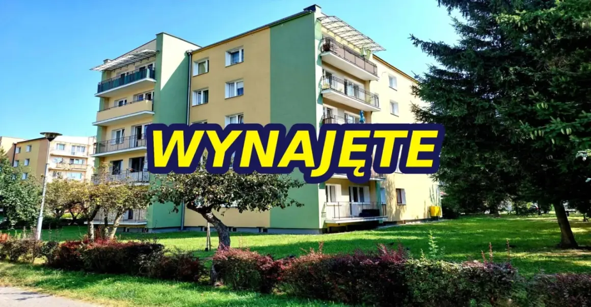 Blok mieszkalny z balkonami, zielony teren. Napis "WYNAJĘTE" sugeruje, że szukasz mieszkań do wynajęcia Zamość.