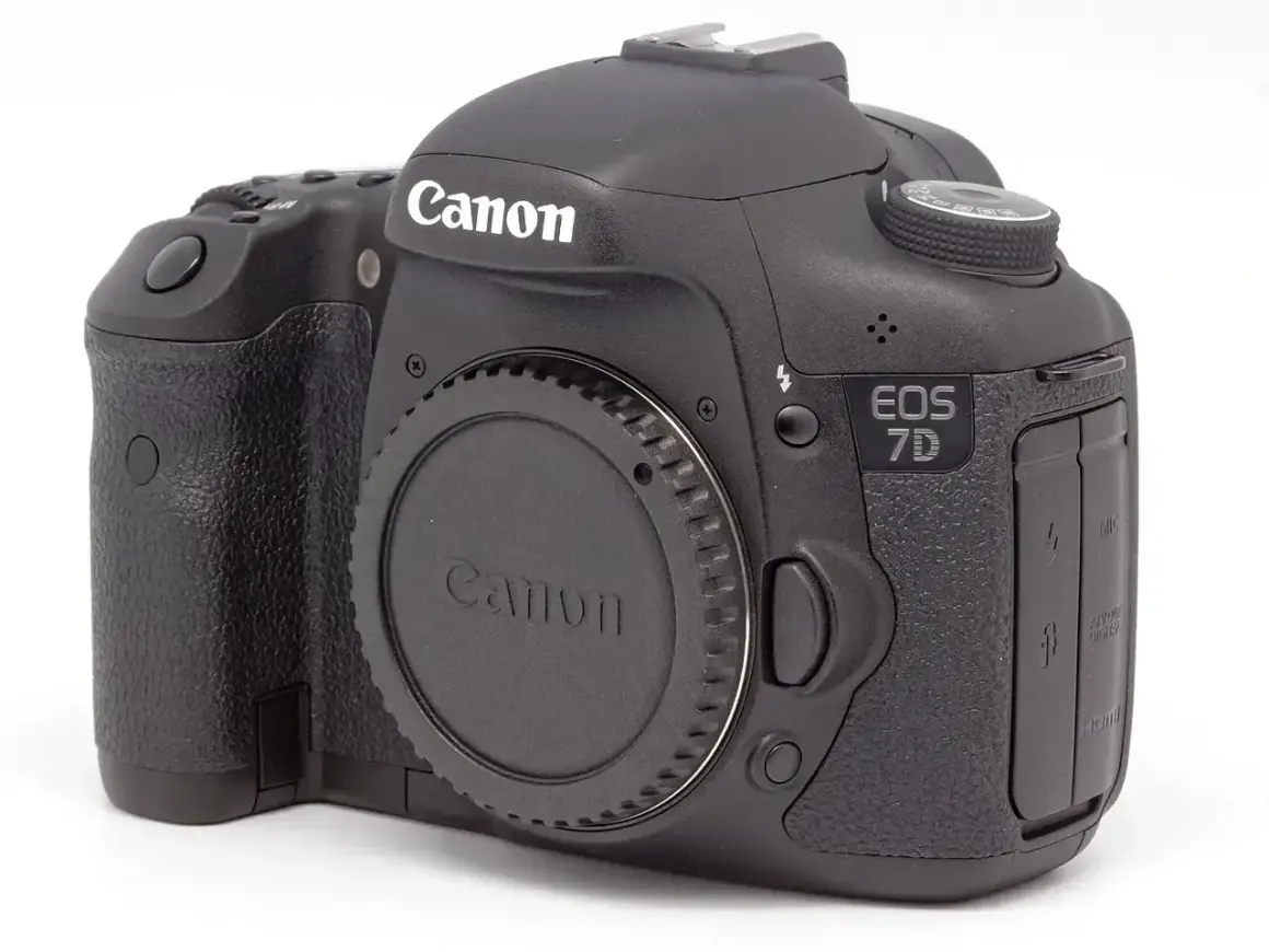Czarny aparat Canon EOS 7D. Zastanawiasz się dslr co to? To właśnie taki aparat, z wymiennym obiektywem i lustrem.