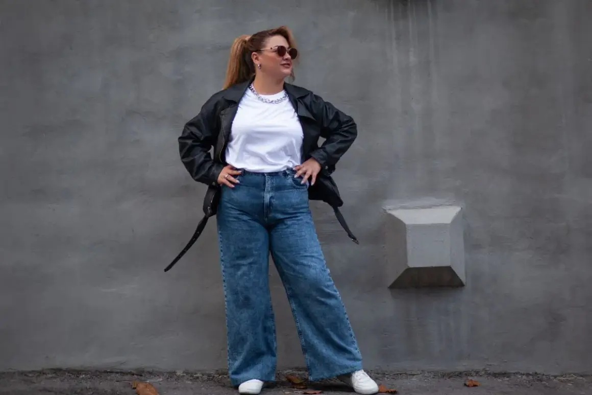 Kobieta w skórzanej kurtce i jeansach z wysokim stanem, idealnych dla puszystych. Stylowy look na co dzień.